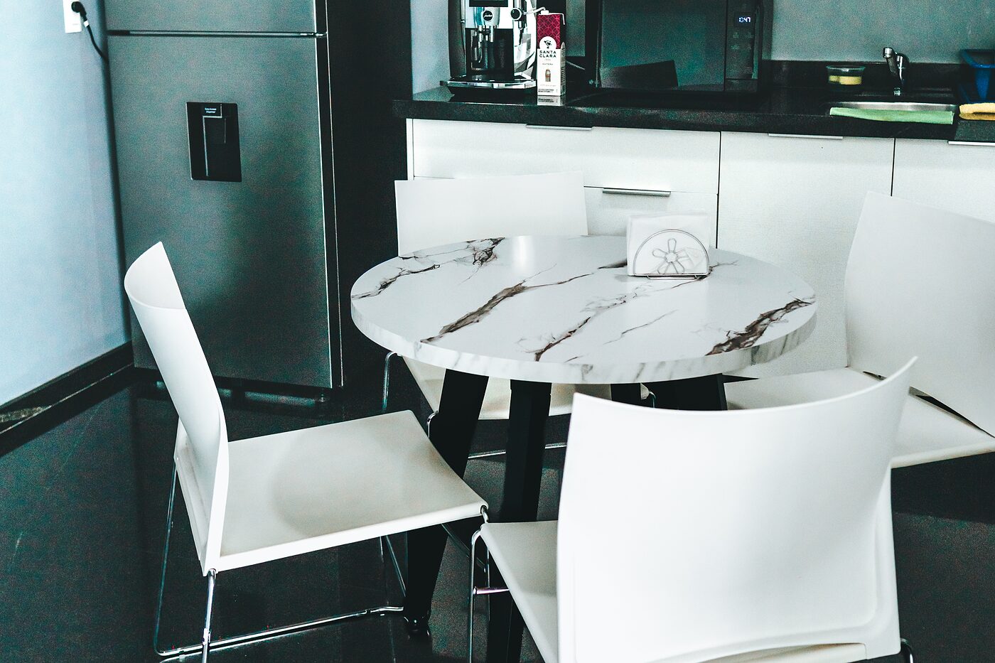 Cafetería con barra, cafetera, refrigerador y mesa de mármol