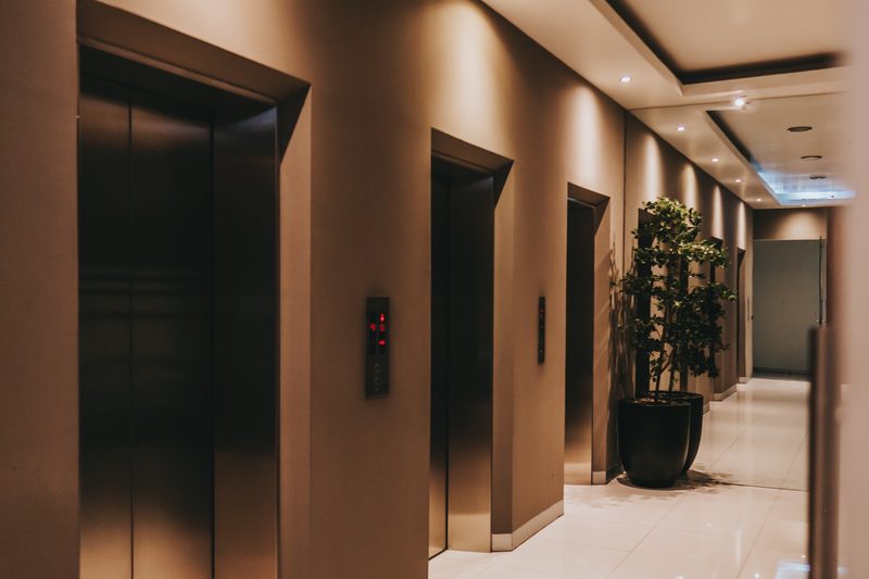 Pasillo de elevadores del Mezzanine con luz indirecta cálida